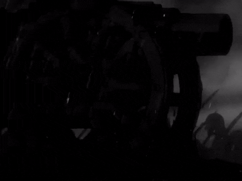 a black and white photo of a cannon with a few soldiers in the background