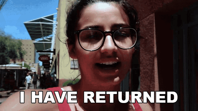 a woman wearing glasses and a red tank top says i have returned