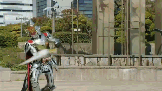 a man in a knight costume is holding a sword in front of a building