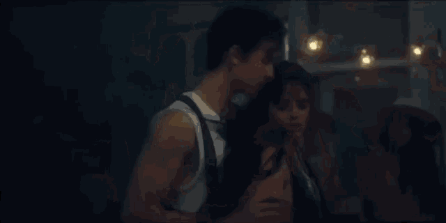 a man and a woman are dancing in a dark room .