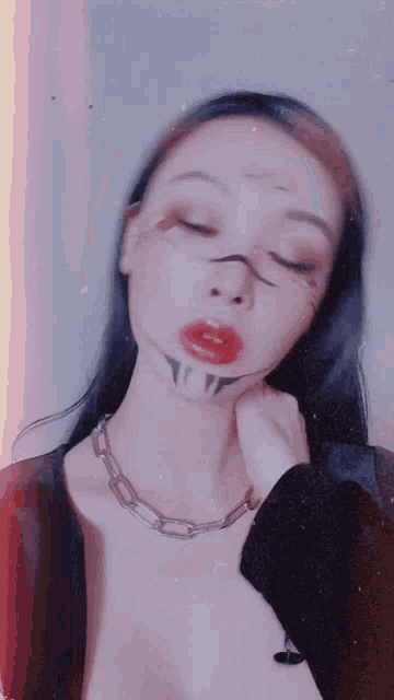a woman with a tattoo on her neck is wearing a chain around her neck