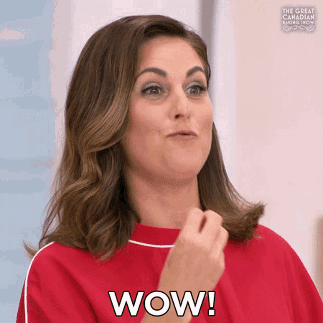 a woman in a red shirt is making a surprised face and saying wow