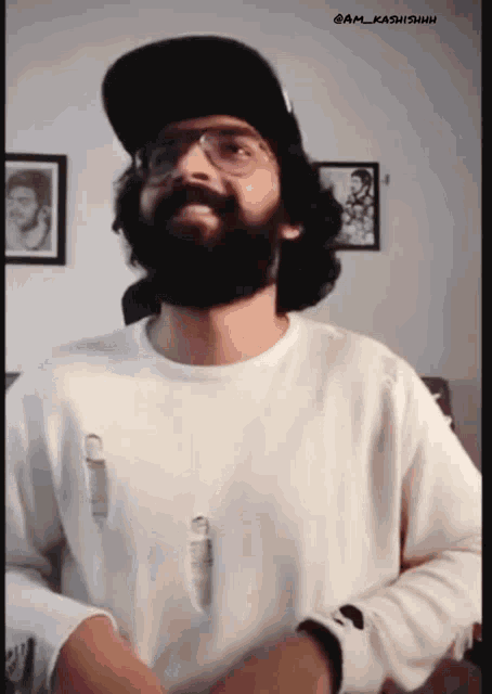a man with a beard and glasses is wearing a hat and a white shirt