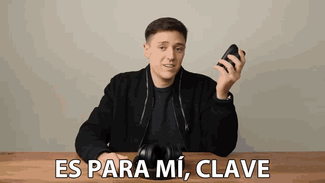 a man holding a cell phone with the words es para mi clave written below him