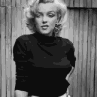 a black and white photo of marilyn monroe wearing a black turtleneck sweater