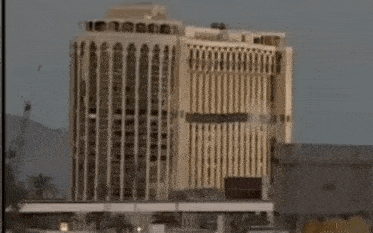 a very tall building with a lot of windows and a bridge in the background