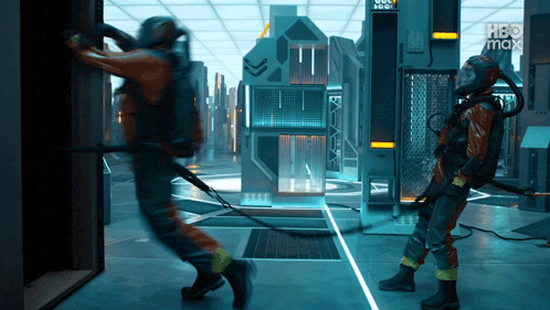 two people in a room with a sign that says hbo max in the background