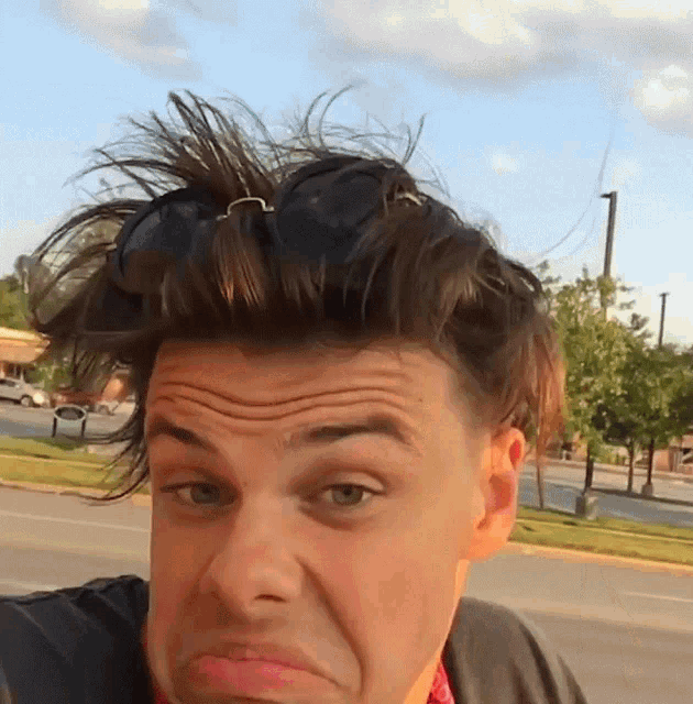 a man with sunglasses on his head is making a face