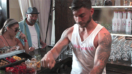 a man wearing a white tank top with the word supreme on the front