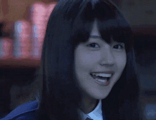 a woman with long black hair is smiling and looking at the camera
