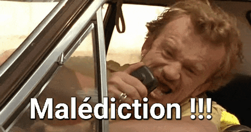 a man in a car is talking on a cell phone and the word maldiction is written above him