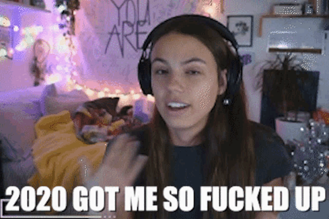 a woman wearing headphones with the words 2020 got me so fucked up below her