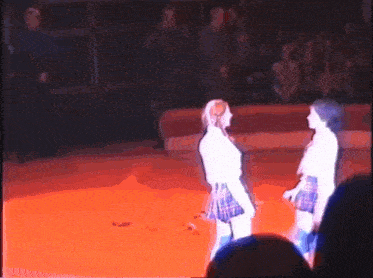 two women in plaid skirts are standing next to each other