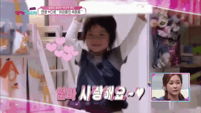a little girl is being interviewed by a woman with korean writing