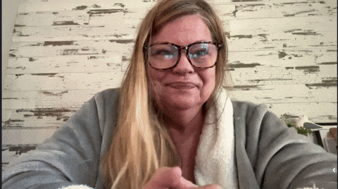 a woman wearing glasses and a grey sweater