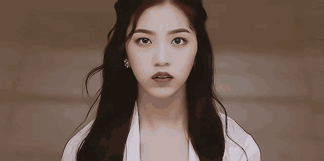 a close up of a woman 's face with a white shirt on