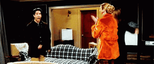 a man and a woman are standing in front of a couch .