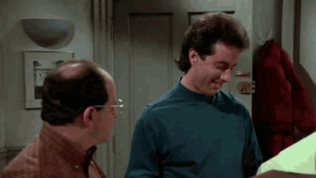 two men are standing next to each other in front of a door .