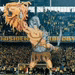 a statue of a man holding a lion 's head in front of a crowd of people in a stadium .