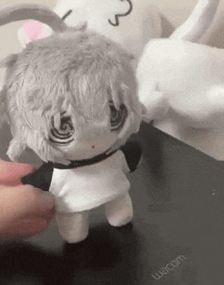 a person is holding a stuffed animal that looks like a rabbit .