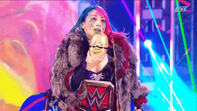 a woman in a fur coat is holding a gold trophy in her hand .