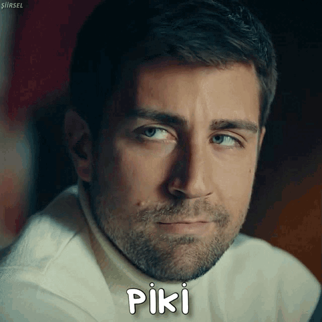 a close up of a man 's face with the word piki written below it