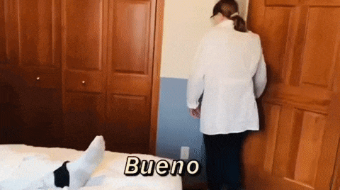 a woman in a lab coat is standing next to a bed .