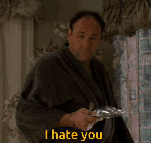 a man in a robe is holding a tray and says " i hate you "