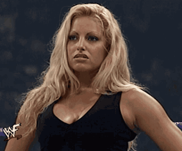a blonde woman is wearing a black tank top with the w logo on her arm