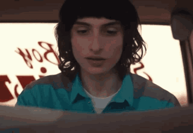 a man in a blue shirt is looking at a piece of paper