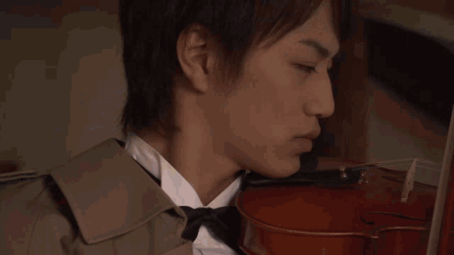 a man playing a violin with a bow tie