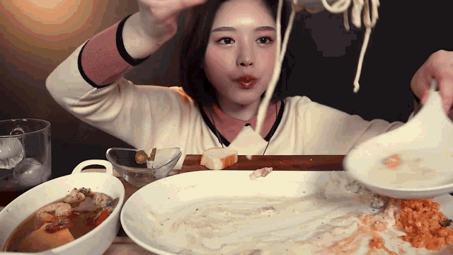 a woman is sitting at a table with plates of food