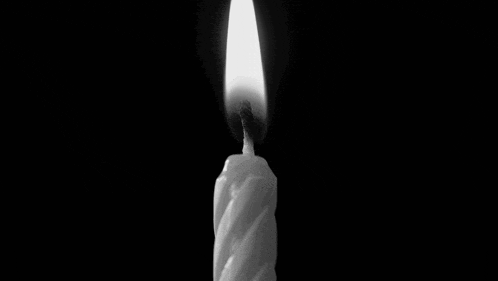 a black and white photo of a candle with smoke behind it