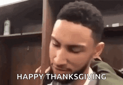 a man with a beard is standing in a locker room with his eyes closed and says `` happy thanksgiving '' .