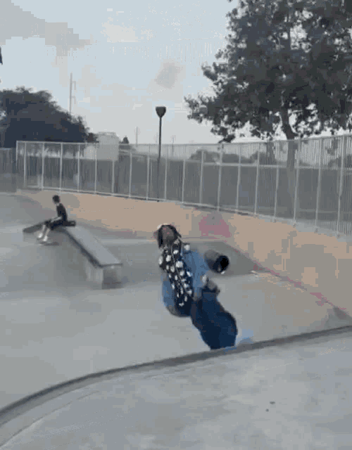 a skateboarder is doing a trick on a ramp at a skate park