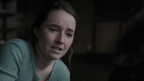 a woman with a sad look on her face is next to a sign that says are just f * * king wrong