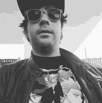 a black and white photo of a man wearing sunglasses and a baseball cap