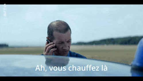 a man is talking on a cell phone and the words ah vous chauffez la are below him