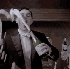 a man in a tuxedo holding a bottle of champagne