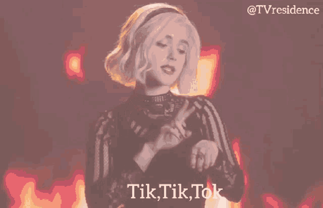 a woman is dancing in front of a fire and the words tik tik tok are on the bottom