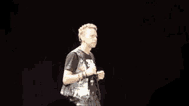 a man is singing into a microphone while wearing gloves
