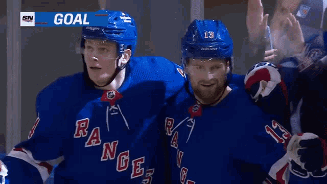 two hockey players wearing blue rangers jerseys are standing next to each other
