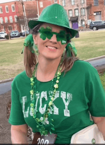 a woman wearing a green shirt that says " lucky "