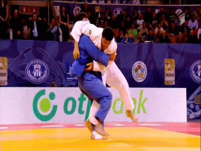 a judo match is being played in front of a sign that says cotrak