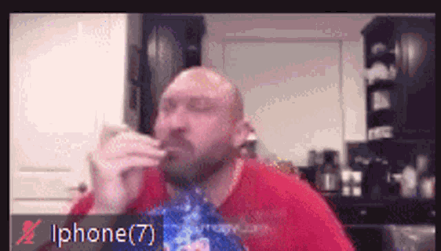 a man in a red shirt is drinking from a bottle with the number 7 on the bottom right
