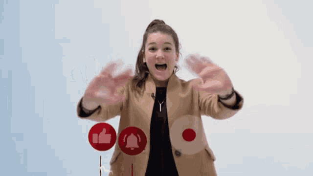 a woman is waving her hands in front of a red button that says " subscribe "