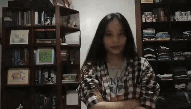 a girl wearing a plaid shirt with nyc on it