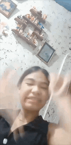 a girl is making a funny face in front of a shelf with toys on it