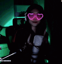 a woman wearing heart shaped glasses and headphones is sitting in front of a microphone