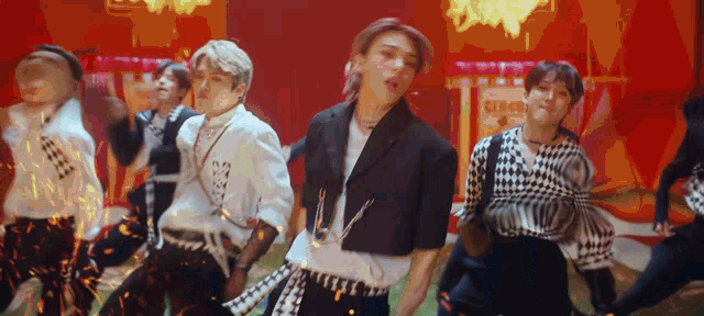 a group of young men are dancing in a room .